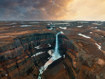 Aerial view on hengifoss waterfall with red stripes sediments in iceland.