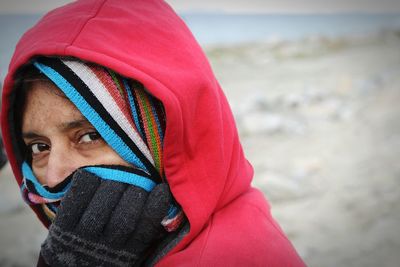 Close-up portrait of woman covering face with scarf