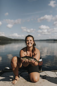 Smiling woman holding fish