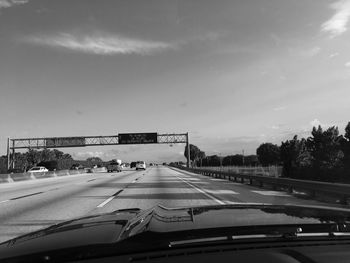 Vehicles on highway against sky seen from car windshield