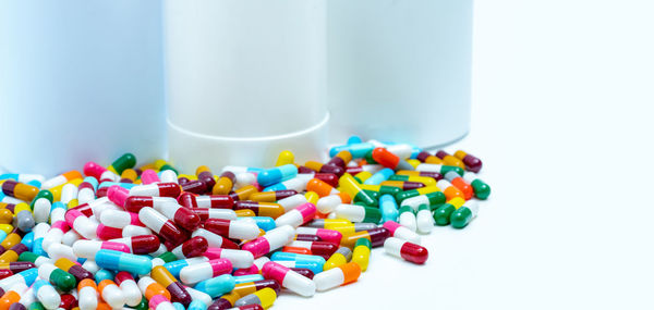 Pile of colorful antibiotic capsule pills on blurred plastic drug bottles. antibiotic drugs.