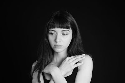 Portrait of woman against black background