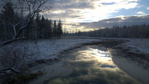 Scenic view of field against cloudy sky during winter