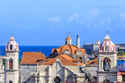 Churches in city by sea against sky