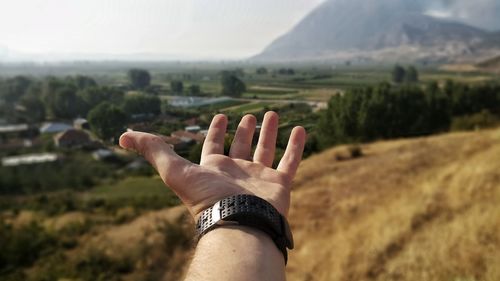 Close-up of woman hand against mountain