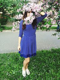 Portrait of woman looking through pink flowers at park