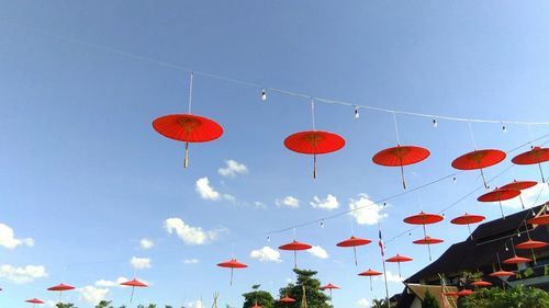 Low angle view of lanterns hanging against sky