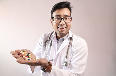 Portrait of smiling young man holding eyeglasses