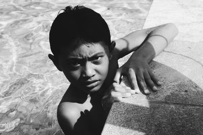 High angle portrait of shirtless boy at poolside