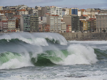 Water splashing in sea against buildings in city