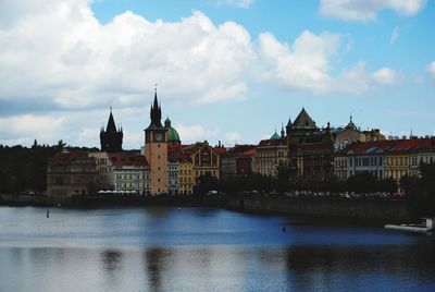 River amidst buildings in city against sky