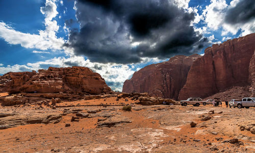 View of rock formations in desert against cloudy sky