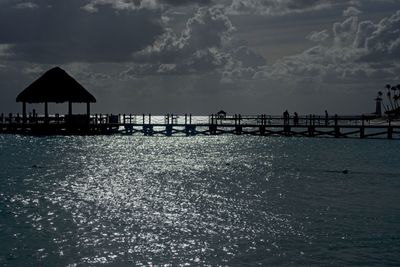 Silhouette pier on sea against sky