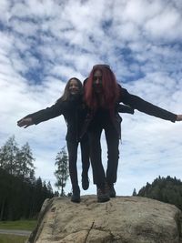 Low angle view of woman standing against sky