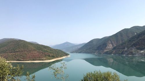 Scenic view of lake and mountains against clear sky