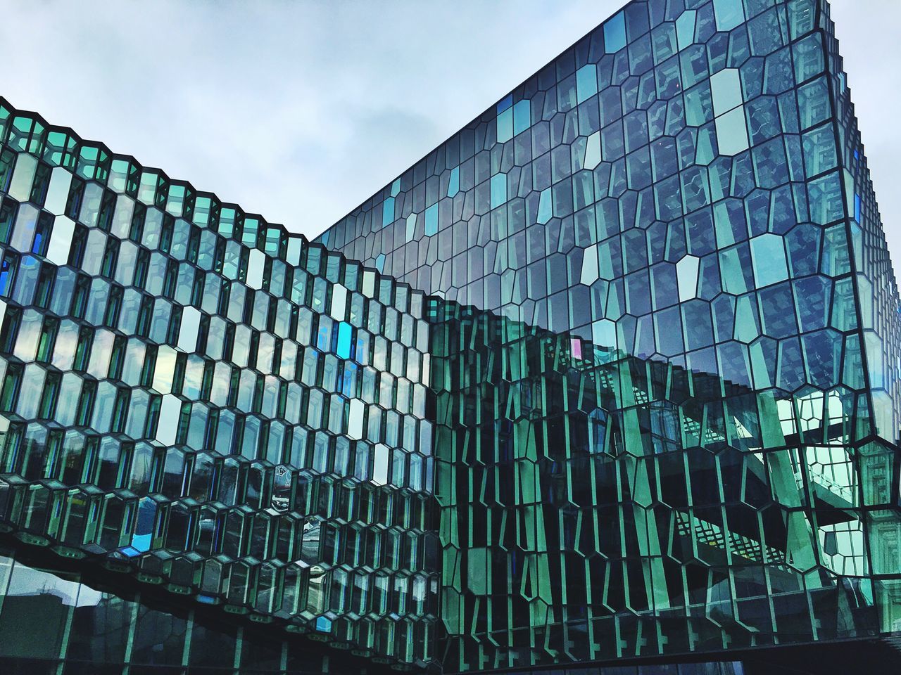 building exterior, architecture, built structure, low angle view, modern, office building, building, glass - material, city, sky, blue, reflection, window, day, pattern, outdoors, skyscraper, no people, tall - high, sunlight