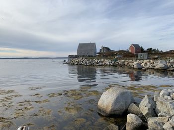 Scenic view of sea by buildings against sky