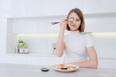 Side view of young woman sitting at home