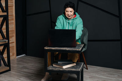 Young man using mobile phone while sitting on table