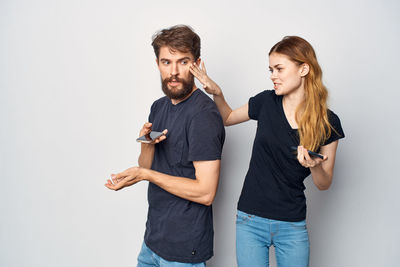 Young couple standing against white background