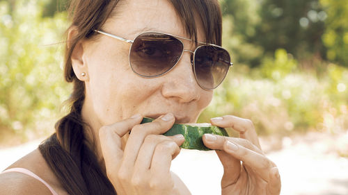 Close-up portrait of woman eating watermelon at beach