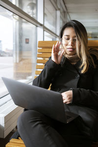 Woman at train station using laptop