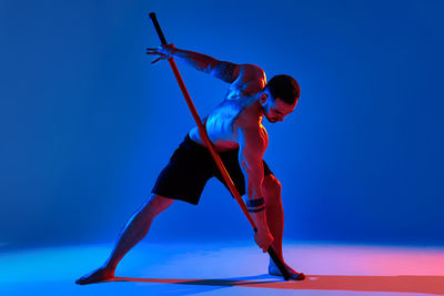 Full length of young man against blue background