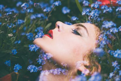 Double exposure of woman and blue flowers