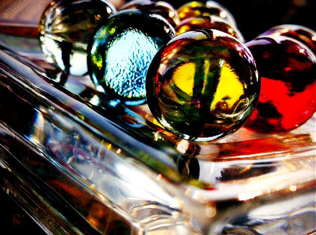 glass - material, close-up, transparent, indoors, multi colored, focus on foreground, shiny, reflection, bubble, still life, sphere, illuminated, glass, no people, red, selective focus, detail, drinking glass, pattern, drop