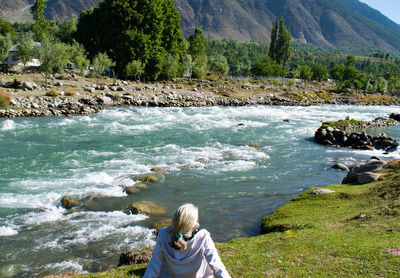 Rear view of woman sitting on beach