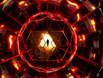 Rear view of man standing against illuminated lights