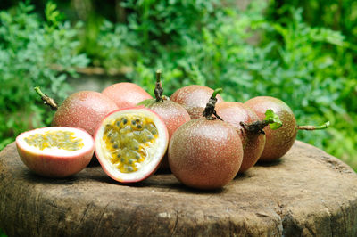 Close-up of passion fruits on cutting board against plants