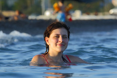 Portrait of young woman swimming in sea