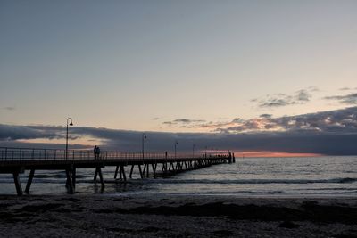 Pier over sea against sky during sunset