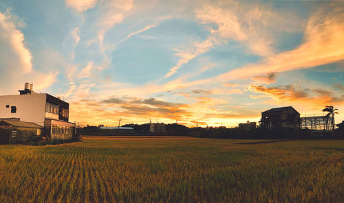 House on field against sky during sunset