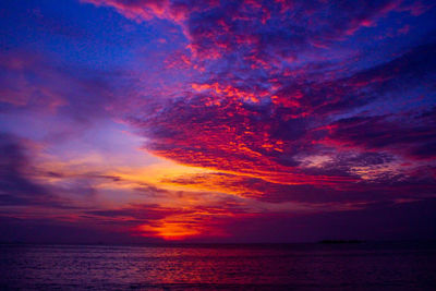 Scenic view of sea against dramatic sky during sunset