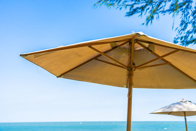 Low angle view of parasols on beach against sky