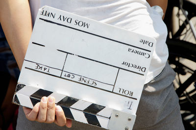 Close-up of man holding clapper board
