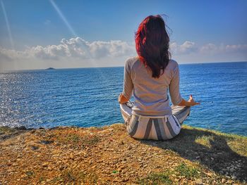 Rear view of woman looking at sea against sky