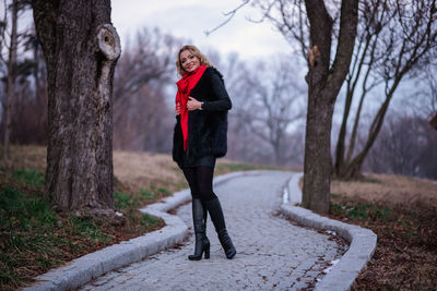 Full length of woman on tree trunk during winter