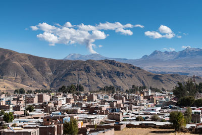 Town by mountains against sky