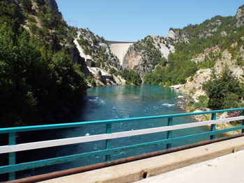 Scenic view of mountains and dam against clear blue sky