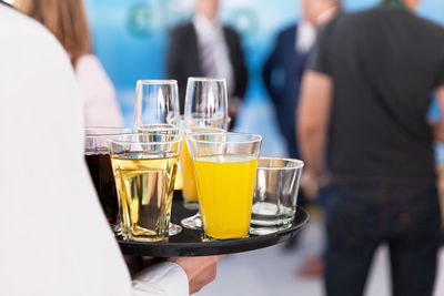 Midsection of man serving drinks in party