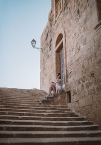 Low angle view of person against building