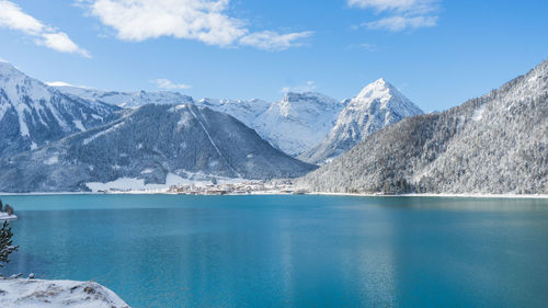 Scenic view of lake and snowcapped mountains against sky