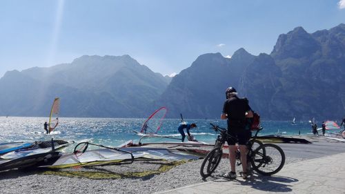 Cyclists and windsurfers in torbole lake, italy