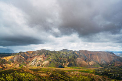 Scenic view of field and mountains against sky