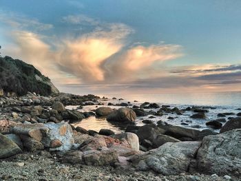 Scenic view of rocks at beach during sunset