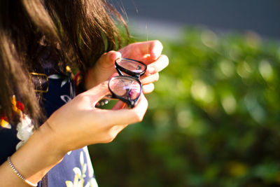 Midsection of woman holding eyeglasses