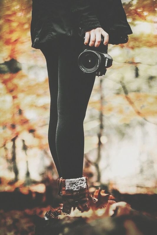 spring, one person, autumn, fashion, adult, black, standing, lifestyles, nature, arts culture and entertainment, footwear, low section, human leg, day, women, clothing, outdoors, young adult, focus on foreground, red, technology, photo shoot, leaf, plant part, shoe, camera, person, leisure activity, tree
